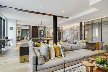 Boston apartment for rent - a living room with a gray couch and a kitchen with glass doors