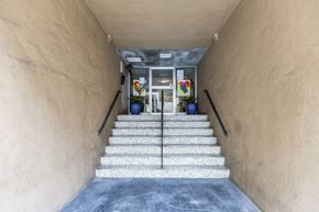 San Francisco apartment for rent - A staircase with a glass railing leading to a door with a glass window.