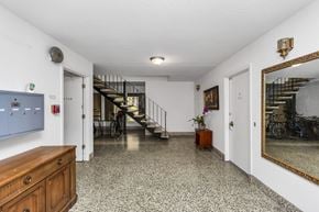 San Francisco apartment for rent - A hallway with a wooden dresser and a mirror on the wall.