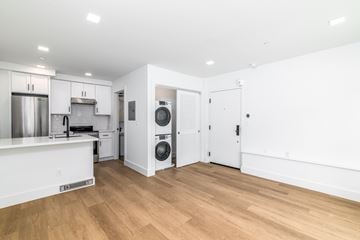 San Francisco apartment for rent - A kitchen with white cabinets and a white island with a refrigerator under it.