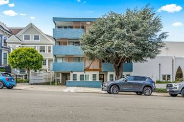 San Francisco apartment for rent - A grey car is parked in front of a blue building.