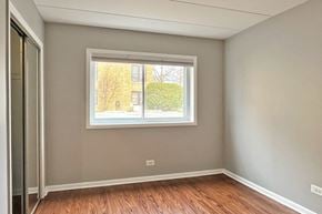 Oak Park apartment for rent - A room with a window showing a view of a building and trees outside.
