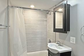 Oak Park apartment for rent - A white sink is on a black vanity in a bathroom.