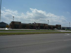 Fargo apartment for rent - A large building with a parking lot in front.