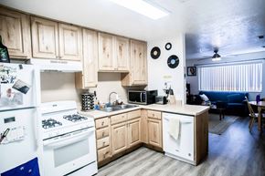 Provo apartment for rent - a kitchen with white appliances and wooden cabinets
