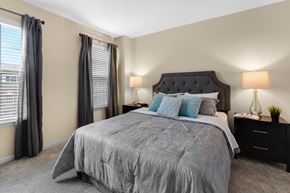 Novi apartment for rent - a bedroom with a large bed and two night stands with lamps