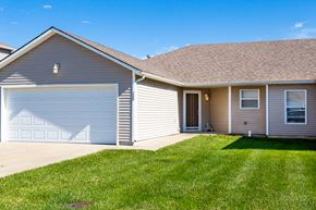 Belton triplex for rent - a house with a garage door and a lawn