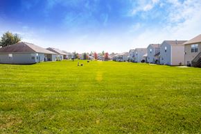 Belton triplex for rent - a green lawn in front of a row of houses