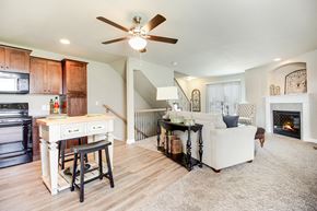 Kansas City townhouse for rent - a living room with a couch and a kitchen and a ceiling fan