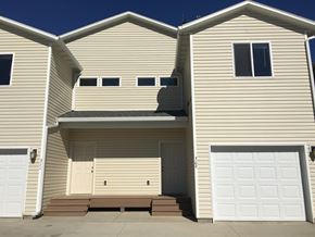 Sidney apartment for rent - a house with two garages and a white garage door
