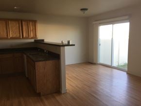 Sidney apartment for rent - an empty kitchen and living room with wood flooring and a sliding glass door