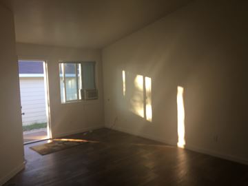 Sidney apartment for rent - an empty living room with wood floors and a window