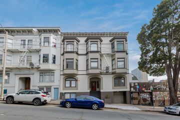 San Francisco apartment for rent - A blue car is parked in front of a white building.