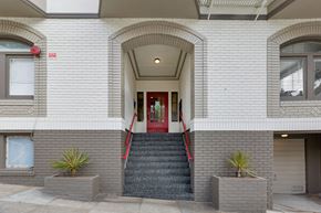 San Francisco apartment for rent - A white building with a red door and steps leading up to it.