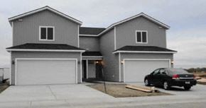Sidney apartment for rent - A two-story house with a car parked in front.