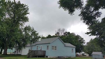 Kearney apartment for rent - a blue and white house with trees and a cloudy sky