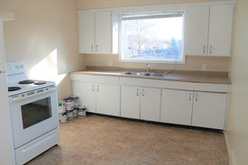 Brandon apartment for rent - a kitchen with white cabinets and a sink and a window