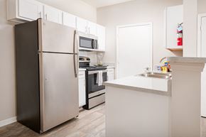 Jackson apartment for rent - a kitchen with white cabinets and stainless steel appliances and a refrigerator