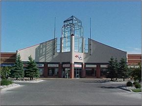 Fargo apartment for rent - A large building with a glass tower on the left side and a red sign on the right side.