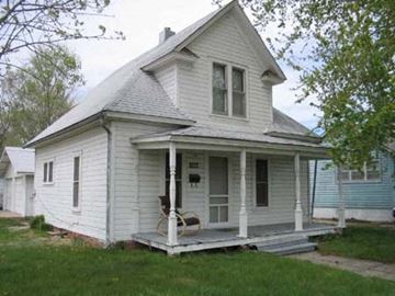 Kearney apartment for rent - a white house with a porch with a chair on it