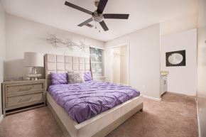 Jackson apartment for rent - A bedroom with a bed, nightstand, and a ceiling fan.