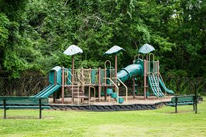 Jackson apartment for rent - A playground with a green slide and yellow umbrellas.