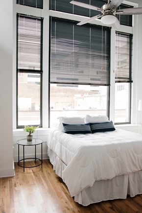 Roanoke apartment for rent - a small bedroom with a bed and large windows