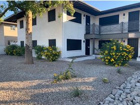 Scottsdale apartment for rent - A white two-story building with a balcony and a tree in front.