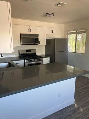 Scottsdale apartment for rent - A kitchen with a stove top oven and a refrigerator.