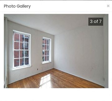 New York apartment for rent - an empty room with a wood floor and two windows