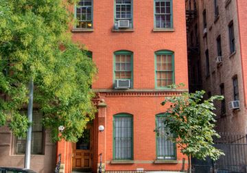 New York apartment for rent - a red brick building with green windows and trees