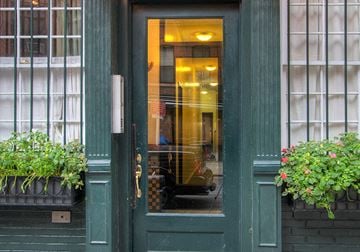 New York apartment for rent - the front door of a restaurant with a reflection of a car in the window
