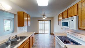 Moorhead townhouse for rent - a kitchen with wood cabinets and white appliances and a sink