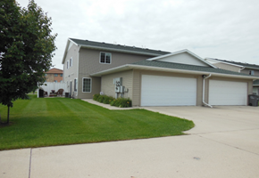 Moorhead townhouse for rent - a house with a driveway and a lawn