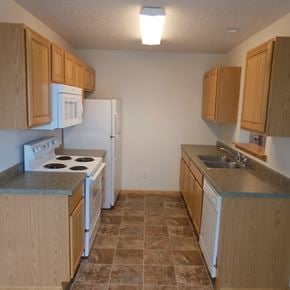 West Fargo townhouse for rent - an empty kitchen with a stove refrigerator and sink