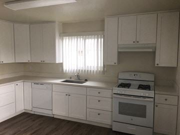 Hollister apartment for rent - a kitchen with white cabinets and a stove and a sink