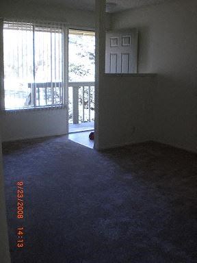 Hollister apartment for rent - an empty living room with a door to a balcony