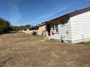 Killeen apartment for rent - A white house with a red door and a brown lawn in front.
