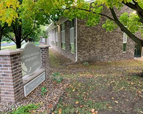 Northfield apartment for rent - a brick building with a sign in front of a tree