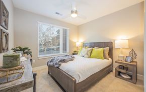 Greenville apartment for rent - a bedroom with a large bed and a ceiling fan
