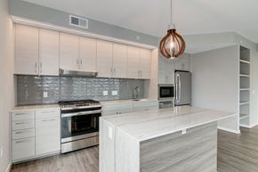 Washington apartment for rent - A modern kitchen with a stainless steel refrigerator and a copper pendant light.