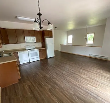 West Fargo apartment for rent - A kitchen with wooden floors and white appliances.