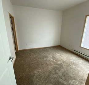 West Fargo apartment for rent - A room with a carpeted floor and a window with blinds.