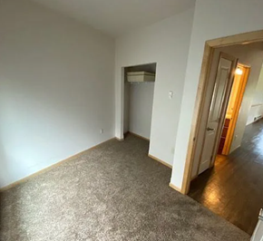 West Fargo apartment for rent - A room with a carpeted floor and a doorway leading to another room.