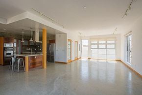 Santa Barbara apartment for rent - A large, empty room with a kitchen area to the left and a doorway leading to another room to the right.