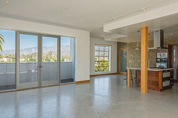 Santa Barbara apartment for rent - A spacious living room with a kitchen area and sliding glass doors.