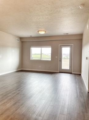 Hickman apartment for rent - an empty living room with wood floors and a door