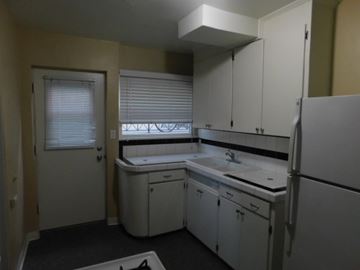 San Diego apartment for rent - a kitchen with white cabinets and a refrigerator and a sink