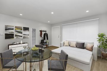 San Francisco apartment for rent - A modern living room with a glass table and grey chairs.