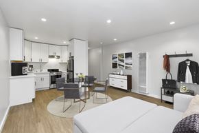 San Francisco apartment for rent - A modern kitchen with white cabinets and a dining table with chairs.